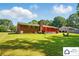 Large backyard with a red brick house and a bright green lawn, with a fire pit in the distance at 707 Hester Dr, Dallas, NC 28034