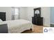 Bedroom with a white bedspread and a dark wood dresser with a mirror, next to a window at 707 Hester Dr, Dallas, NC 28034