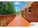 Spacious red deck offers outdoor entertaining with brick home, chimney, and treelined backdrop at 707 Hester Dr, Dallas, NC 28034