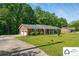A brick home with an attached two-car garage and a long driveway, surrounded by mature trees at 707 Hester Dr, Dallas, NC 28034