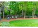 Outdoor seating area situated amongst trees in a beautifully maintained backyard at 7138 Wessynton Dr, Charlotte, NC 28226