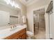 Bathroom with tile floors, marble countertops, wood vanity and glass enclosed shower at 7138 Wessynton Dr, Charlotte, NC 28226