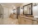 Elegant bathroom featuring double vanities with marble countertops and decorative mirrors and lighting at 7138 Wessynton Dr, Charlotte, NC 28226