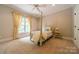 Bright bedroom featuring a poster bed frame, soft carpet, and natural light at 7138 Wessynton Dr, Charlotte, NC 28226
