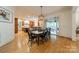 An open dining area features hardwood floors, modern lighting, and access to a sunroom and a gourmet kitchen at 7138 Wessynton Dr, Charlotte, NC 28226