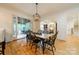 Dining room with hardwood floors, modern chandelier, adjacent to a sunroom and a living room with fireplace at 7138 Wessynton Dr, Charlotte, NC 28226
