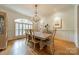 Elegant dining room boasts a large window, chandelier and hardwood flooring at 7138 Wessynton Dr, Charlotte, NC 28226