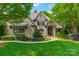 Charming brick home featuring a manicured lawn, mature trees, and elegant landscaping at 7138 Wessynton Dr, Charlotte, NC 28226