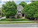 Charming brick home featuring a manicured lawn, mature trees, and elegant landscaping at 7138 Wessynton Dr, Charlotte, NC 28226