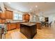 Gourmet kitchen with custom cabinetry, center island, hardwood floors, and open layout to the dining and living areas at 7138 Wessynton Dr, Charlotte, NC 28226