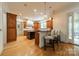 Expansive kitchen featuring custom cabinetry, hardwood floors, a center island with breakfast bar, and access to the sunroom at 7138 Wessynton Dr, Charlotte, NC 28226