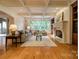 Spacious living room with coffered ceilings, hardwood floors, a stone fireplace, and large windows overlooking a green space at 7138 Wessynton Dr, Charlotte, NC 28226