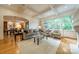 Open-concept living room with large windows, hardwood floors, and views into the dining room and verdant backyard at 7138 Wessynton Dr, Charlotte, NC 28226