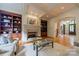 Bright living room showcasing a stone fireplace, hardwood floors, custom built-ins, and an open floor plan to the entryway at 7138 Wessynton Dr, Charlotte, NC 28226