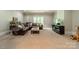 Spacious living room featuring a large leather sectional, neutral carpet, and a wall-mounted TV at 7138 Wessynton Dr, Charlotte, NC 28226