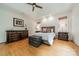 Bright main bedroom features tray ceilings, wood floors, and bedside tables with lamps at 7138 Wessynton Dr, Charlotte, NC 28226