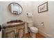 Stylish powder room features a carved vanity with a marble countertop and decorative mirror at 7138 Wessynton Dr, Charlotte, NC 28226