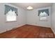 Bedroom featuring hardwood floors, neutral walls, and two windows with curtains at 805 Waverly Pl # 16, Statesville, NC 28677