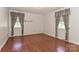 Spacious bedroom with hardwood floors, neutral walls, and two windows with classic patterned curtains at 805 Waverly Pl # 16, Statesville, NC 28677