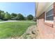 Corner view of a well maintained red brick home, nice landscaping, and a green lawn at 805 Waverly Pl # 16, Statesville, NC 28677
