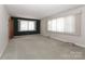 Bright living room with large windows and neutral carpet provides a comfortable space for relaxation at 805 Waverly Pl # 16, Statesville, NC 28677