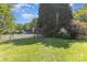 Backyard view featuring a playhouse, shed and lawn, partially enclosed by a white picket fence at 815 Clearbrook Rd, Matthews, NC 28105