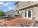 An outdoor brick patio features dining and lounging furniture with backyard access through glass doors at 815 Clearbrook Rd, Matthews, NC 28105