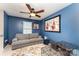 Bedroom features blue walls, a ceiling fan, artwork, and a comfortable couch at 8734 Meadowmont View Dr, Charlotte, NC 28269