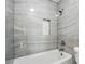 Bathroom featuring gray tile walls, a built-in niche, and a shower head perfect for relaxation at 8833 Cavonnier Ln, Charlotte, NC 28216
