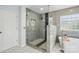 Modern bathroom featuring a glass shower, soaking tub, and marble tile flooring at 8833 Cavonnier Ln, Charlotte, NC 28216