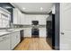 Well-lit kitchen featuring white cabinetry, stainless steel appliances, and wood-look flooring at 8833 Cavonnier Ln, Charlotte, NC 28216