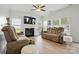 Comfortable living room with a fireplace, ceiling fan, and two sofas for relaxation at 8833 Cavonnier Ln, Charlotte, NC 28216