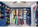 Custom walk-in closet with ample storage space and blue built-in shelving for clothing and accessories at 8833 Cavonnier Ln, Charlotte, NC 28216