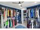 Spacious walk-in closet featuring custom blue shelving, ample hanging space, and room for shoe storage at 8833 Cavonnier Ln, Charlotte, NC 28216