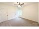 Light-filled bedroom features neutral carpet, a ceiling fan, and two doors for easy access at Lot 1 New Pineola Rd, Charlotte, NC 28208