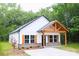 Beautiful exterior of a home with a light brick foundation, dark trim, and a covered front porch at Lot 1 New Pineola Rd, Charlotte, NC 28208