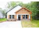 Charming new construction home featuring a farmhouse style with wood accents and shutters with a well manicured lawn and concrete driveway at Lot 1 New Pineola Rd, Charlotte, NC 28208