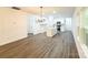 Bright open concept kitchen with stainless steel appliances, white cabinets, an island with sink and wood-look flooring at Lot 1 New Pineola Rd, Charlotte, NC 28208