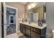 Bathroom featuring dark cabinets, a large mirror, and tile flooring, leading to an adjacent room at 1026 Slew O Gold Ln, Indian Trail, NC 28079