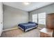 Cozy bedroom with plush carpeting, a double window, and a comfortable blue bedspread at 1026 Slew O Gold Ln, Indian Trail, NC 28079
