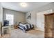 Cozy bedroom with striped bedding, a desk, and carpet flooring, showcasing natural light at 1026 Slew O Gold Ln, Indian Trail, NC 28079