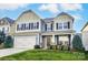 Charming two-story home with a well-manicured lawn, attached garage and classic architectural details at 1026 Slew O Gold Ln, Indian Trail, NC 28079