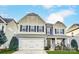 Two-story home with a light-colored exterior, attached garage, trimmed lawn, and dark trim at 1026 Slew O Gold Ln, Indian Trail, NC 28079