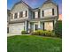 Charming two-story home featuring a spacious garage, well-manicured lawn, and inviting front porch at 1026 Slew O Gold Ln, Indian Trail, NC 28079