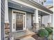 Charming front door with sidelights and transom window, complemented by stone accents and a welcoming porch at 1026 Slew O Gold Ln, Indian Trail, NC 28079