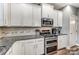 This kitchen features white cabinets, granite countertops, stainless appliances, and stylish tile backsplash at 1026 Slew O Gold Ln, Indian Trail, NC 28079