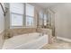 Clean bathroom with soaking tub and tiled glass-enclosed shower at 1026 Slew O Gold Ln, Indian Trail, NC 28079