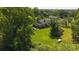 Aerial view of brick home on a sprawling lot featuring mature trees, lush green grass and ancillary structures at 1040 Nc 90 W Hwy, Taylorsville, NC 20681