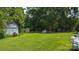 A spacious backyard with multiple storage buildings surrounded by lush trees and green grass at 1040 Nc 90 W Hwy, Taylorsville, NC 20681