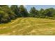 An aerial view of a large green field surrounded by lush trees and clear blue skies at 1040 Nc 90 W Hwy, Taylorsville, NC 20681